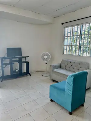 a living room with a couch and a fan at Apartamento hostal oasis 2 in Puerto Colombia