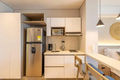 a kitchen with a stainless steel refrigerator and white cabinets at Cosy seaside studio with sunset view in Cartagena de Indias