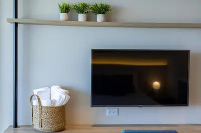 a flat screen tv on a wall with a basket at Cosy seaside studio with sunset view in Cartagena de Indias