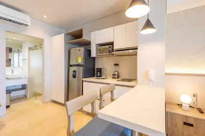 a kitchen with a white counter top and a table at Cosy seaside studio with sunset view in Cartagena de Indias