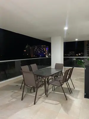 a table and chairs in a room with a view of a city at Acogedor apartamento en Bello Horizonte in Santa Marta