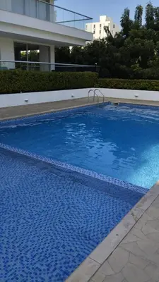 a large blue swimming pool in front of a building at Acogedor apartamento en Bello Horizonte in Santa Marta