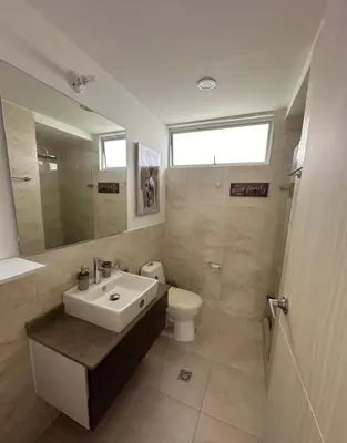 a bathroom with a sink and a toilet and a mirror at Acogedor apartamento en Bello Horizonte in Santa Marta