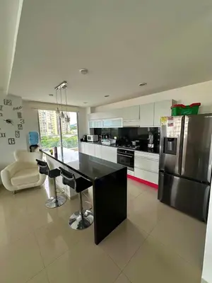a kitchen with a black counter and a refrigerator at Acogedor apartamento en Bello Horizonte in Santa Marta