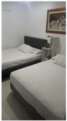 a bedroom with two beds and a picture on the wall at Apartastudio 1 Habitacion - Manga in Cartagena de Indias