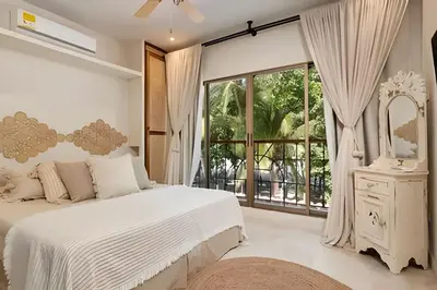 a bedroom with a white bed and a large window at Modern and cozy Beachfront house Santa Marta 7pax in Simón Bolívar International Airport