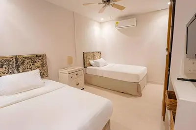 a bedroom with two beds and a television in it at Modern and cozy Beachfront house Santa Marta 7pax in Simón Bolívar International Airport