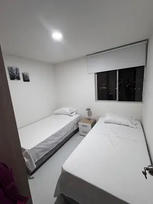 two beds in a white room with a window at Apartmento en Ciudad Mallorquín in Puerto Colombia