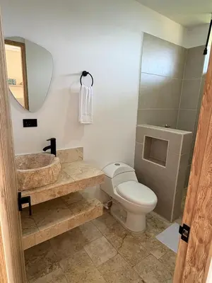 a bathroom with a toilet and a sink and a mirror at Forest Condominio in Coveñas