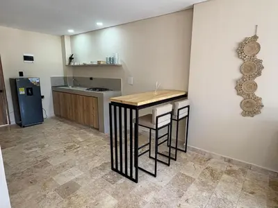 a kitchen with a table and a refrigerator at Forest Condominio in Coveñas