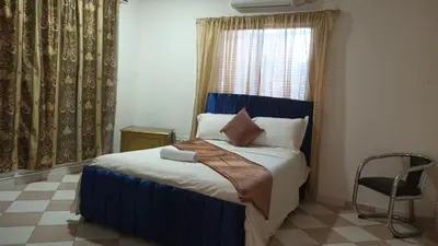 a bedroom with a blue bed with a window and a chair at Prado alto inn in Barranquilla