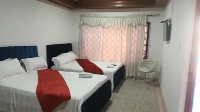 a room with two beds and a window at Prado alto inn in Barranquilla