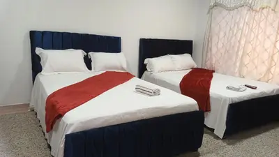 two beds in a hotel room with towels on them at Prado alto inn in Barranquilla