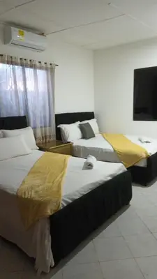 a hotel room with two beds and a flat screen tv at Prado alto inn in Barranquilla