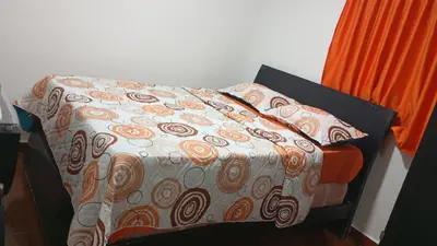 a bed with a comforter and pillows on it at Apartamento #4 in Puerto Colombia