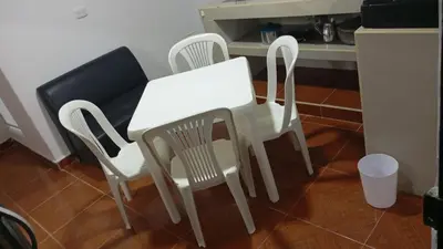 two white chairs and a white table in a kitchen at Apartamento #4 in Puerto Colombia
