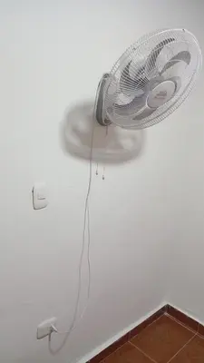 a white fan attached to a ceiling with a cord at Apartamento #4 in Puerto Colombia
