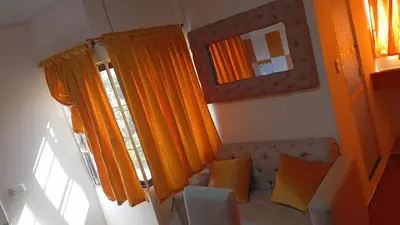 a living room with orange curtains and a couch at Apartamento #5 in Puerto Colombia