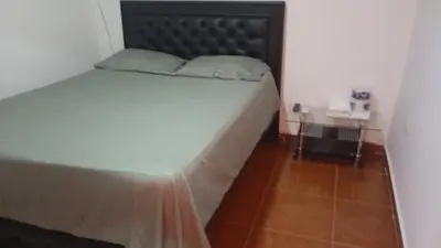 a bedroom with a large bed with a black headboard at Apartamento #5 in Puerto Colombia