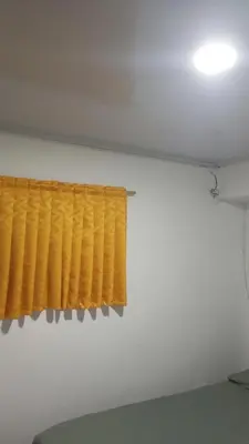 a yellow curtain in a room with a bed at Apartamento #5 in Puerto Colombia