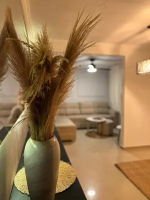 a vase filled with grass on a table in a living room at the best view of Barranquilla in Barranquilla