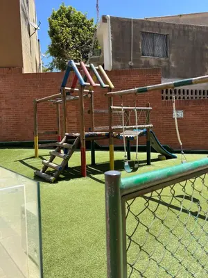 a playground with a swing set on a tennis court at the best view of Barranquilla in Barranquilla