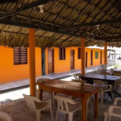 a patio with tables and chairs in a building at Cabañas Capilla Del Mar in San Bernardo del Viento