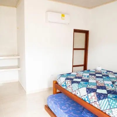 a bedroom with a bed with a quilt on it at Cabañas Capilla Del Mar in San Bernardo del Viento