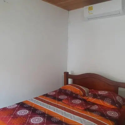 a bed with colorful blankets on it in a room at Cabañas Capilla Del Mar in San Bernardo del Viento