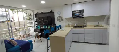 a kitchen with white cabinets and blue chairs in a room at Apto para 6, cerca a la ciudad amurallada in Cartagena de Indias