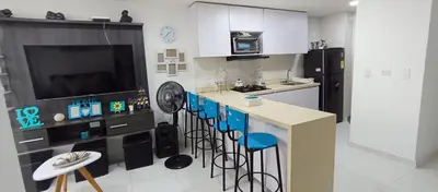 a kitchen with a bar with stools and a counter top at Apto para 6, cerca a la ciudad amurallada in Cartagena de Indias