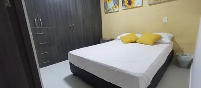 a bedroom with a bed with two yellow pillows at Apto para 6, cerca a la ciudad amurallada in Cartagena de Indias