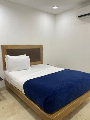 a bedroom with a bed with a blue blanket at Hotel Odonata Real in Cartagena de Indias