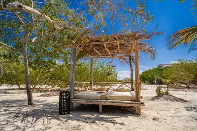a bed in the sand on the beach at Casa del Mar by Al Alma in San Onofre