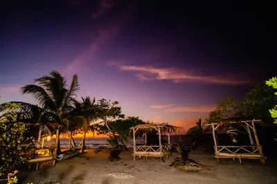 a beach with two chairs and a rainbow in the sky at Casa del Mar by Al Alma in San Onofre