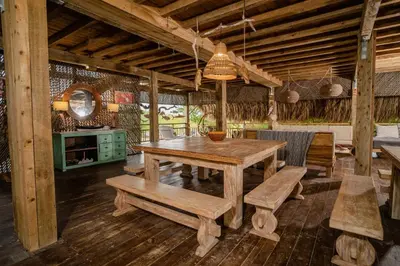 a dining room with a wooden table and benches at Casa del Mar by Al Alma in San Onofre