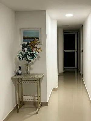 a hallway with a vase of flowers on a table at Acogedor y Moderno Apartamento en Barranquilla in Barranquilla