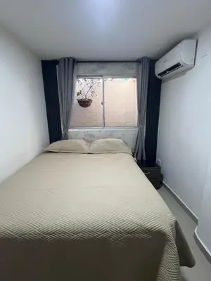 a bed in a small room with a window at Acogedor y Moderno Apartamento en Barranquilla in Barranquilla