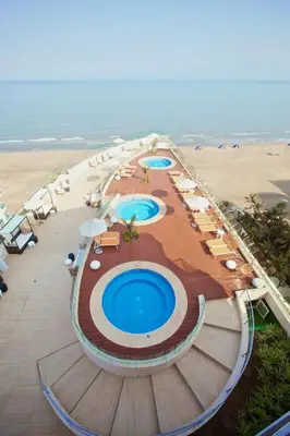 an aerial view of a resort with two pools and umbrellas at Beachfront Apartment at Radisson Hotel in Cartagena de Indias