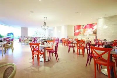 a dining room with red chairs and tables in a restaurant at Beachfront Apartment at Radisson Hotel in Cartagena de Indias