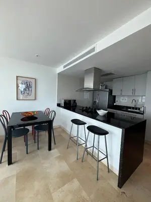 a kitchen with a black table and some chairs at Beachfront Apartment at Radisson Hotel in Cartagena de Indias