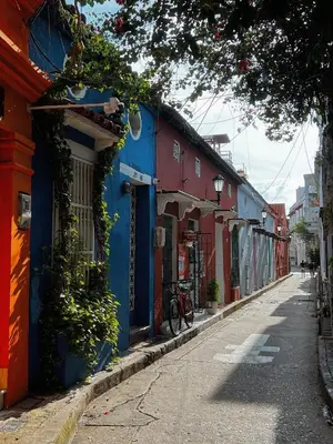 a narrow street with colorful buildings in a city at Art House Getsemaní in Cartagena de Indias
