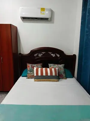 a bed with a wooden headboard and pillows on it at Art House Getsemaní in Cartagena de Indias