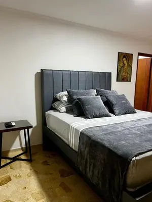 a large bed in a bedroom with a table at Apartamento en Manga in Cartagena de Indias