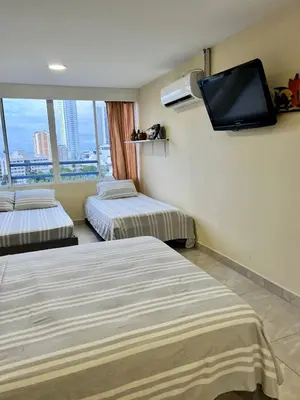 a hotel room with two beds and a flat screen tv at Apartamentos Por dias Laguito Ctg in Cartagena de Indias