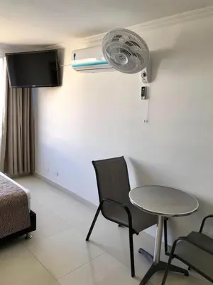 a room with a table and a bed and a fan at Apartamentos Por dias Laguito Ctg in Cartagena de Indias