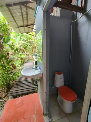 a small bathroom with a toilet and a sink at Lala's Place in Isla Fuerte
