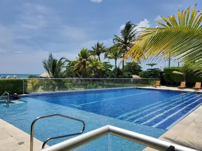 a swimming pool in a resort with palm trees at 2MV-5G Apartamento de 2 Alc Vista al mar con A A Piscina y Wifi in Cartagena de Indias