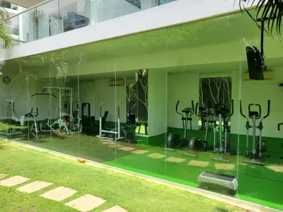 a glass walled gym with exercise equipment in a building at 2MV-5G Apartamento de 2 Alc Vista al mar con A A Piscina y Wifi in Cartagena de Indias