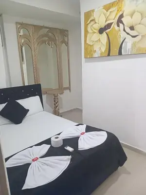 a bedroom with a bed with a black and white blanket at Hostal Asturias Real in Barranquilla
